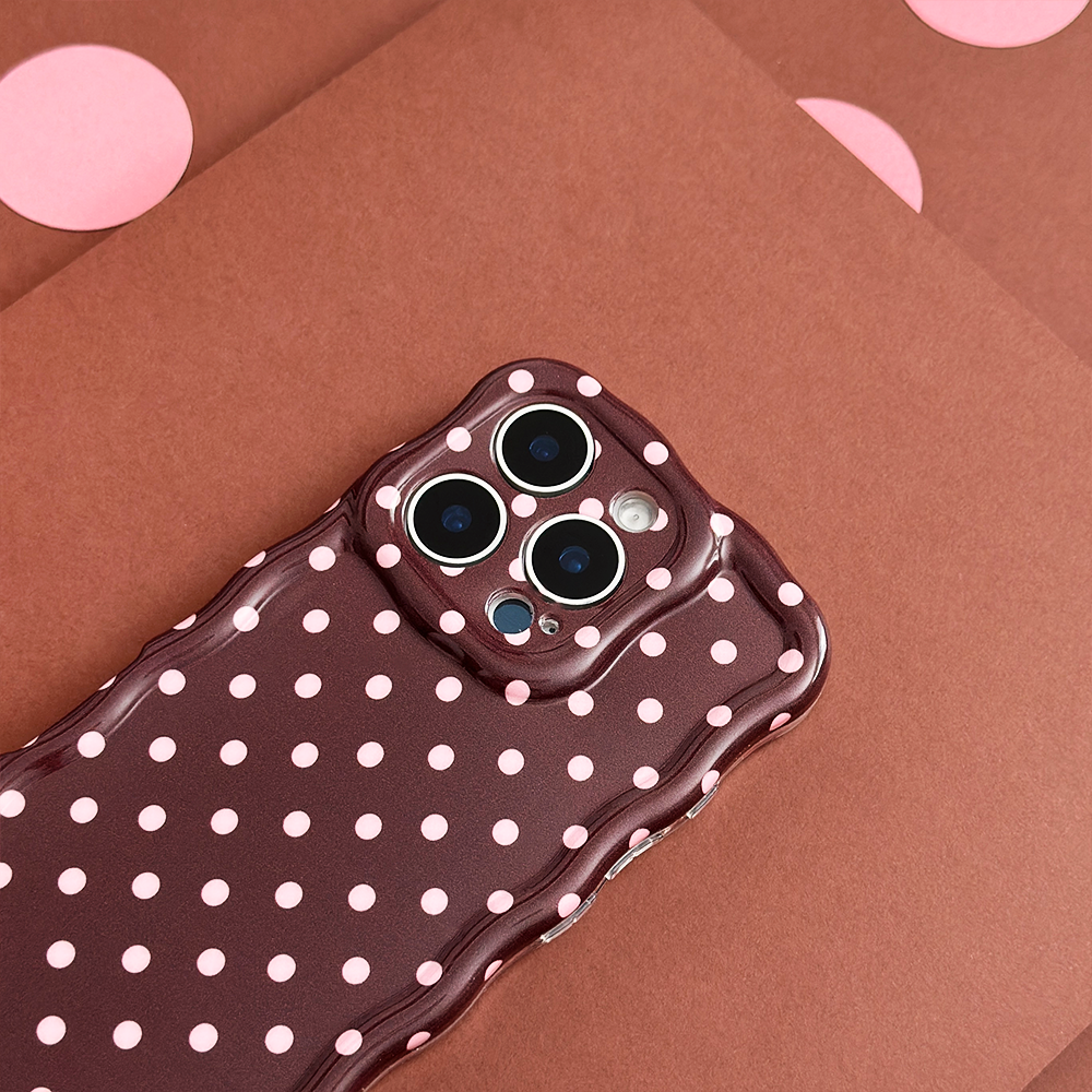 Brown phone case with wavy edges and white polka dots on brown paper featuring pink dots.