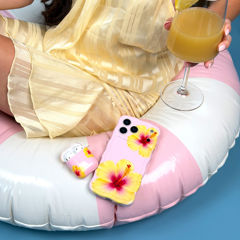 Person lounging on an inflatable ring with a phone case featuring tropical flowers.