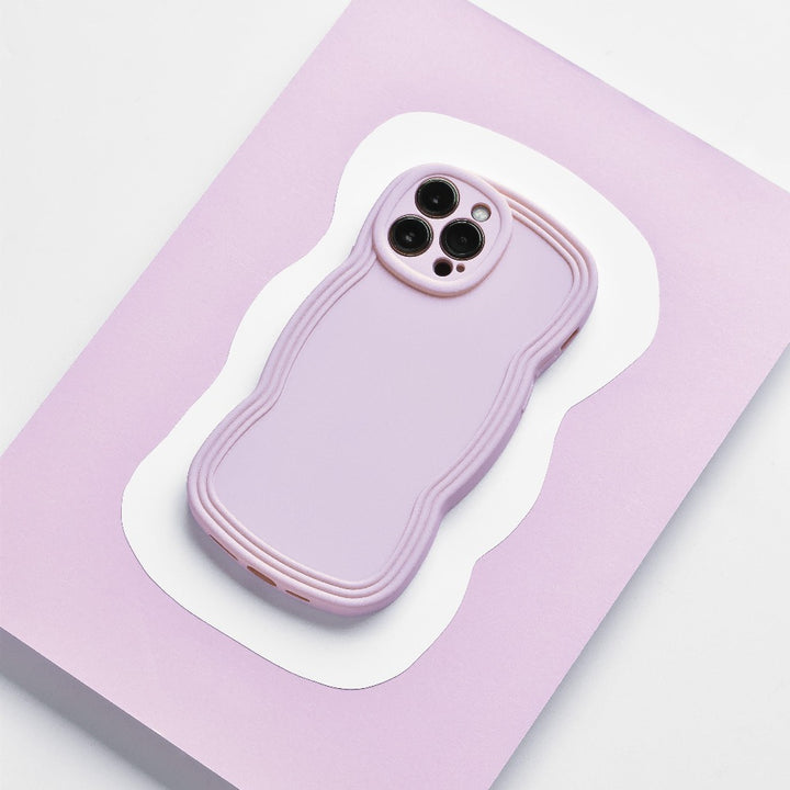 A NAKD Curvy smartphone with a Coconut Lane NAKD Curvy Phone Case - Blueberry, featuring a wavy, textured design, is placed on a light purple and white background. The lightweight case covers the phone completely, with cutouts for the camera and other necessary ports.