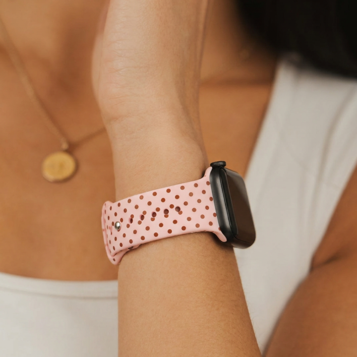Woman wearing the coconut lane pale pink silicone sport band with small brown polka dots.