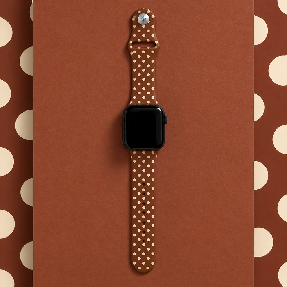 Brown silicone sport band with small cream polka dots, attached to a black Apple Watch smartwatch.