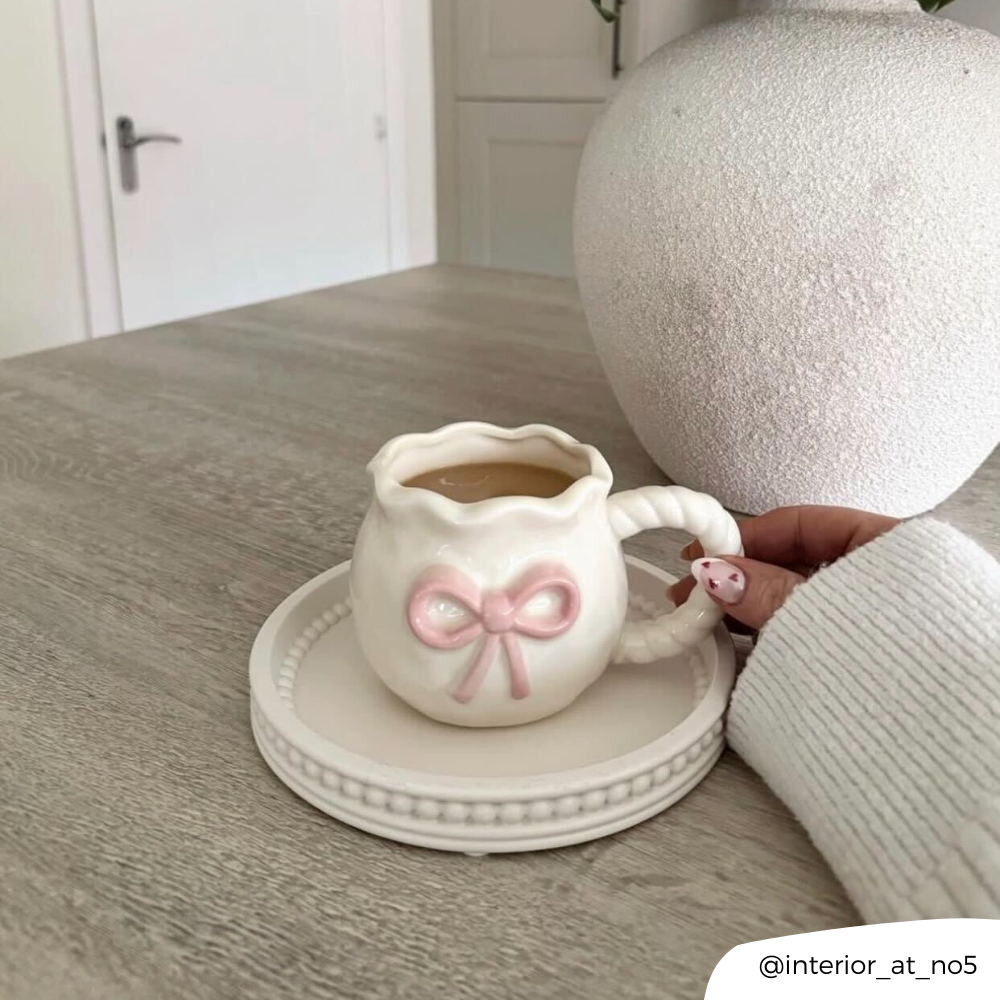 Bow Mug being held on table