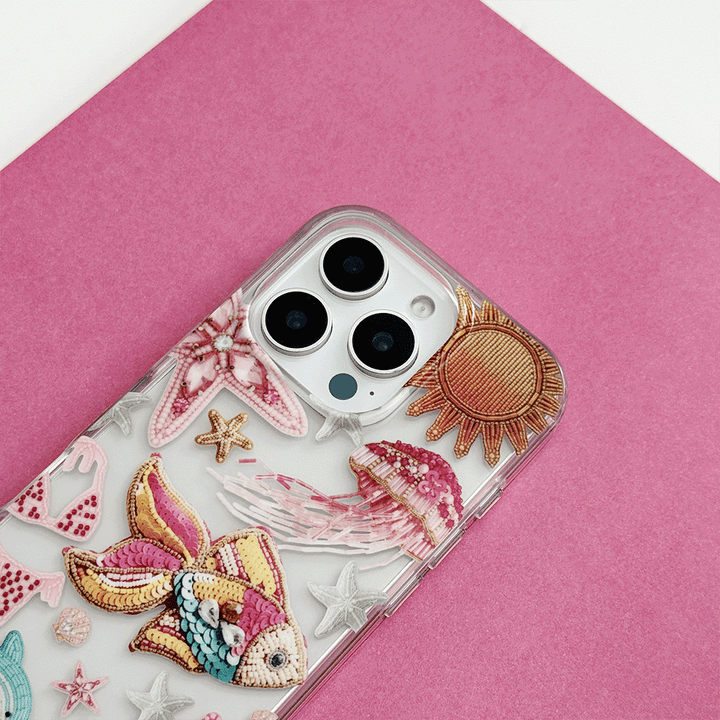 Clear pink phone case with embroidered sea creatures and sun design from Coconut Lane.