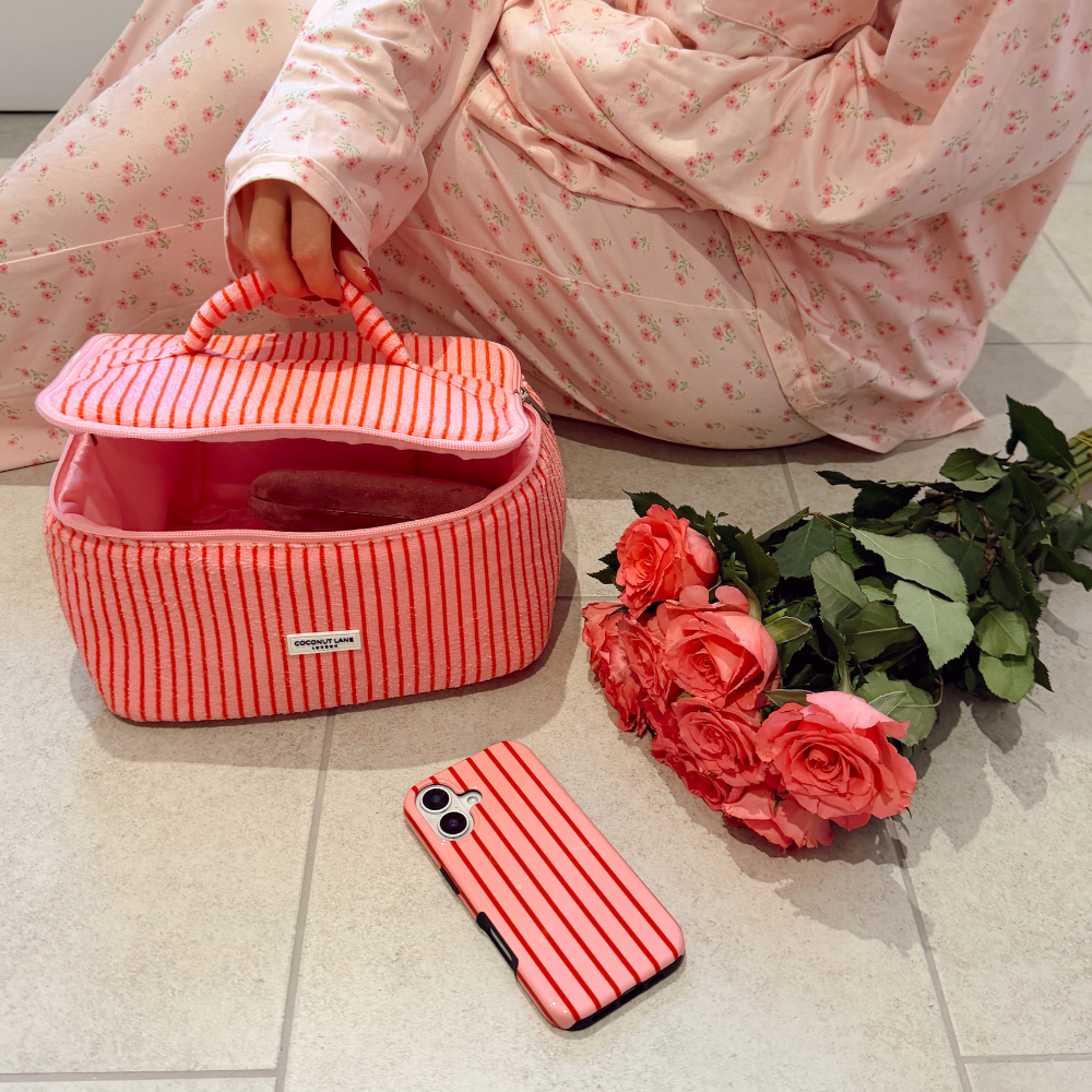 Close up shot in bathroom of the Cherry Vanity Case next to roses and a phone case