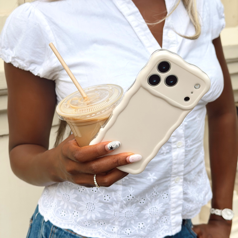 Girl holding her wavy phone case in cloud dancer with iced coffee