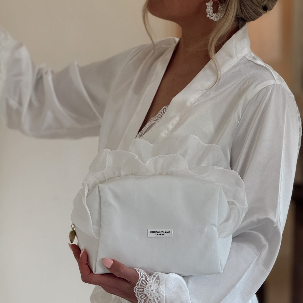 Bride in satin dressing gown holding White Ruffle Satin Makeup Bag