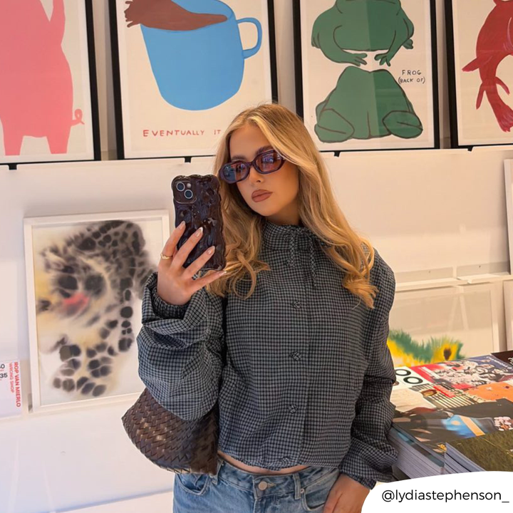 Girl in art gallery taking pictures with 3d bubble phone case in burgundy