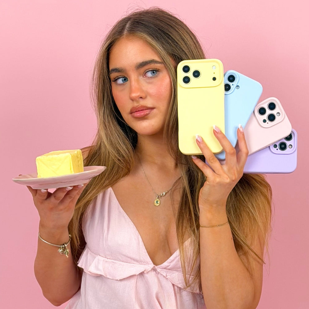 Woman holding a yellow bar of butter and 4 colouful phones on a pink background