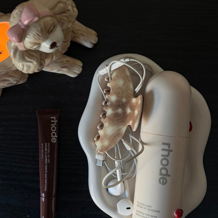 fawn clap clip on a table next to makeup products 