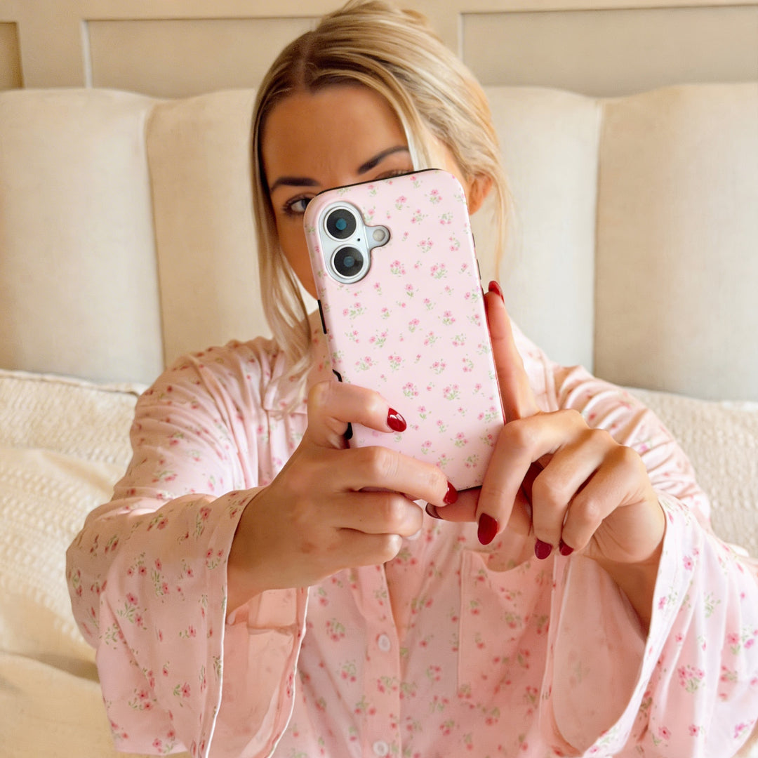 Woman takes a selfie holding a pink Coconut Lane Tough Phone Case with a ditsy floral pattern, case partly covering her face.