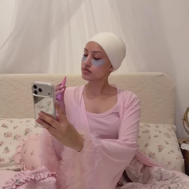 Woman taking a selfie, applying lipbalm, holding an iphone in a mirrored phone case with the text "don't call just text" printed on the back. 